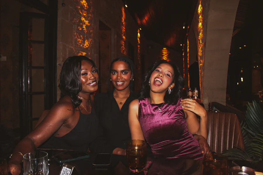 Three women laughing together over dinner